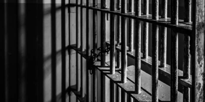 Close up photo of the bars of a prison cell